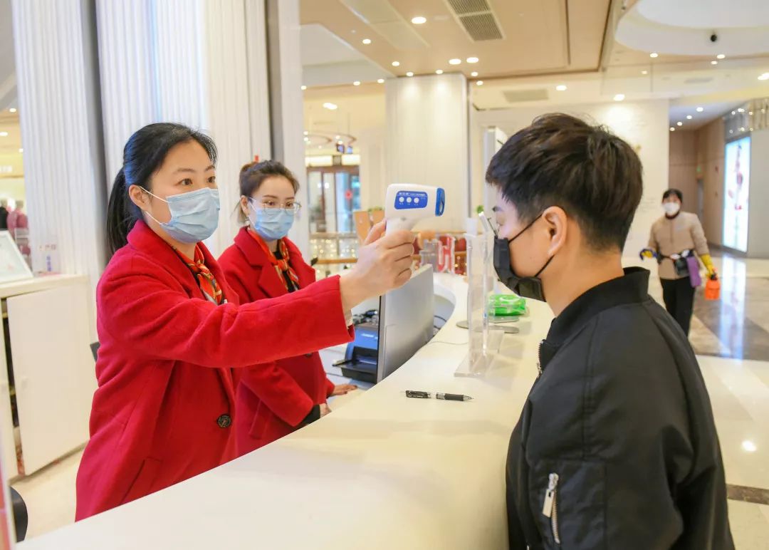 百联世纪购物中心服务台在为顾客测量体温