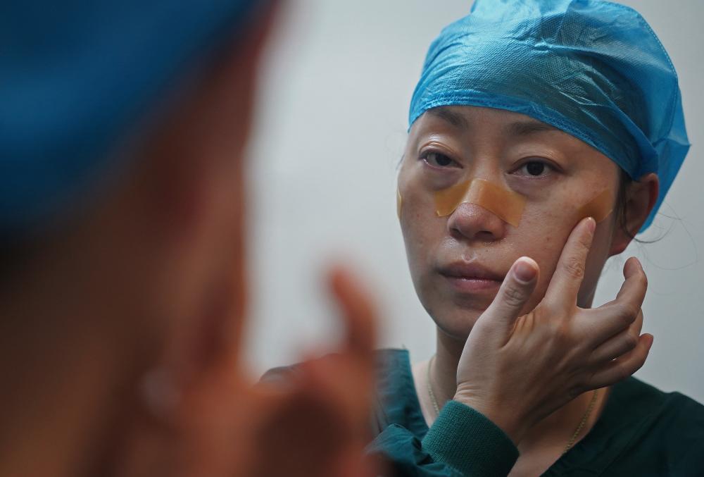 留下了"最美印痕—由于长时间穿戴护目镜和口罩,他们脸上被勒出了