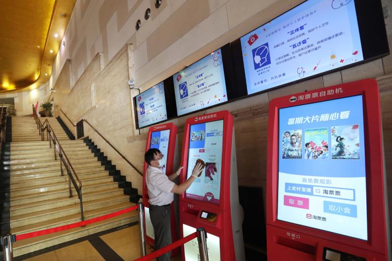2021年8月9日,大光明电影院工作人员对取票机进行消毒,每2小时一次.