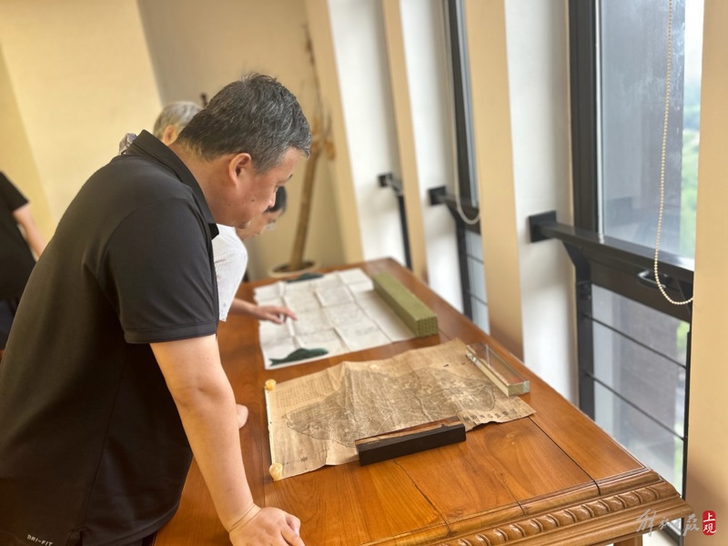 专家学者参观座谈会现场展示的古旧地图 施晨露 摄