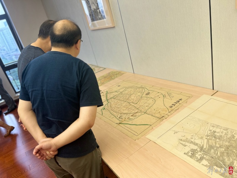 专家学者参观座谈会现场展示的古旧地图 施晨露 摄