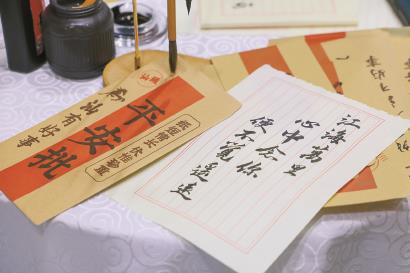 在深圳举行的第二十二届文博会上，汕头展团专为热映电影《给阿嬷的情书》打造电影主题积木打卡墙及“裕丰银信局”场景元素。图为5月21日，工作人员现场为观众写的“侨批”。  新华社记者  毛思倩  摄