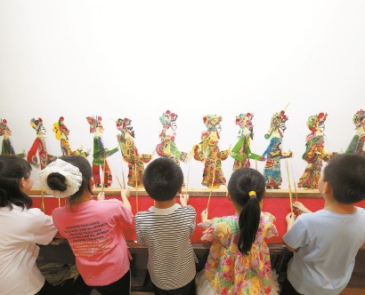 6月12日，在河北省唐山市丰润区文化馆，小朋友在体验皮影戏表演。  新华社发