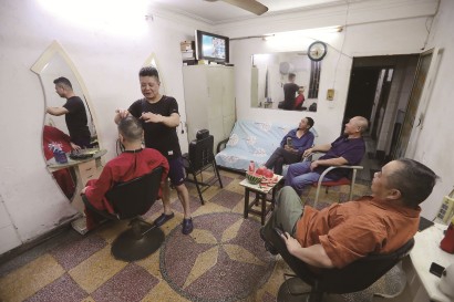 世界杯打响对西藏北路上一家沿街理发店来说犹如节日到来，楼上邻居、店主的球友到这里剪头、观赛。