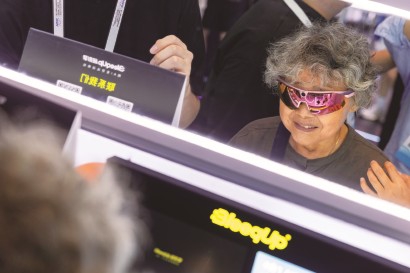 观众试戴AI运动拍摄眼镜。  本报记者  赖鑫琳  摄