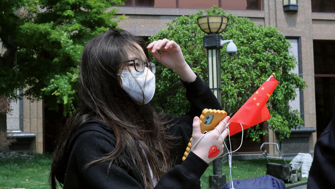 第一批回上海的小留学生结束医学观察离开前她给口罩和手背贴上国旗
