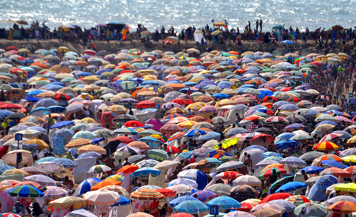 摩洛哥海滩人山人海.7月23日,在摩洛哥拉巴特,人们在海滩消夏.